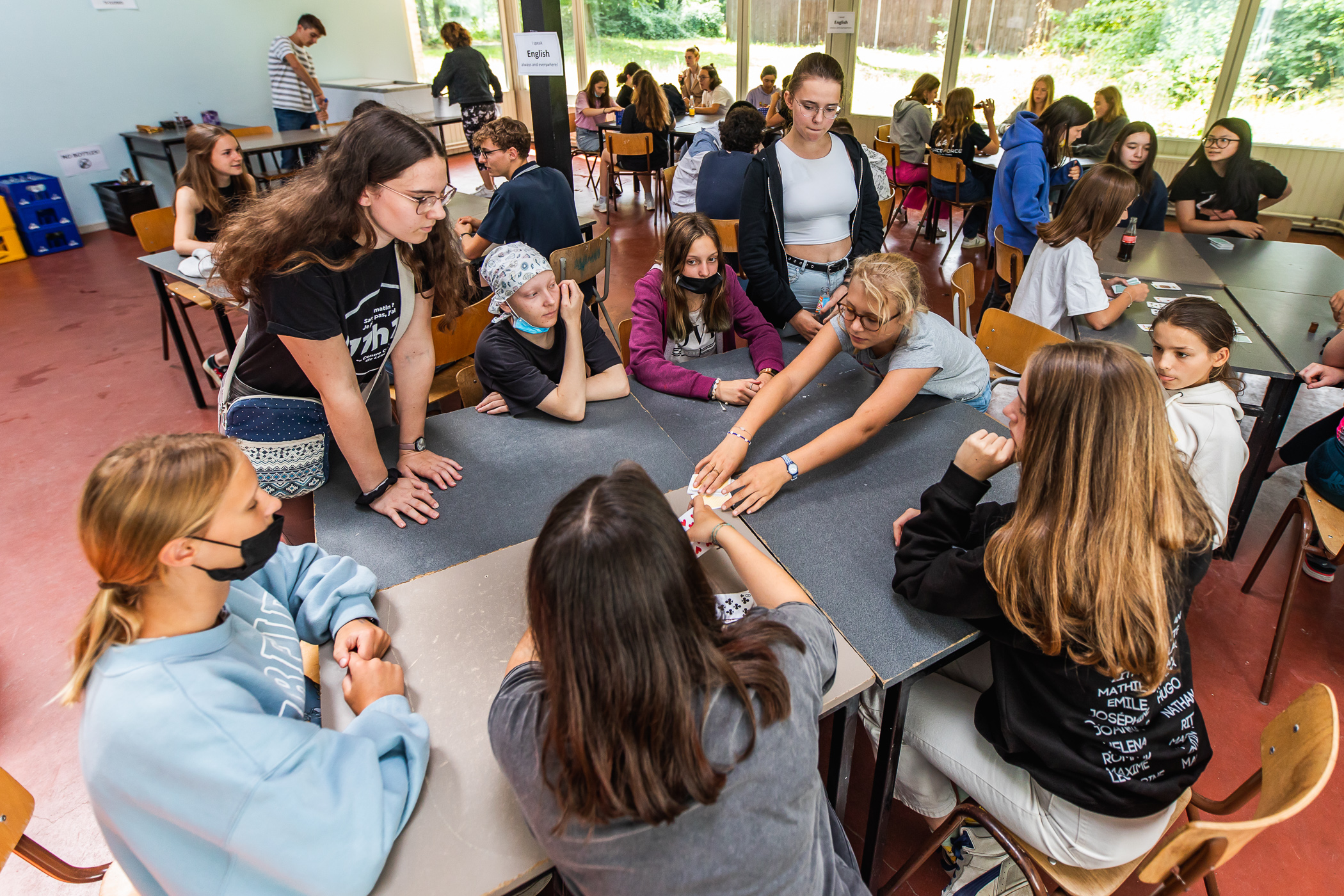 Jongeren in een cirkel rond tafel die spelletjes spelen