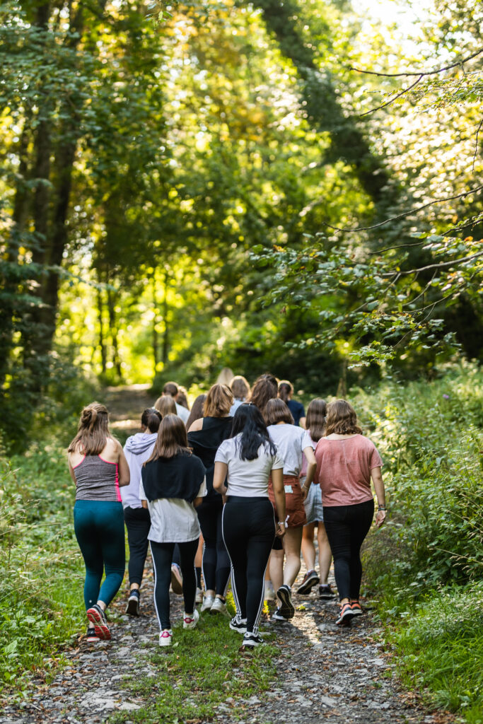 Groep jongeren die wandelen doorheen de natuur van Maredsous Saint Benoît